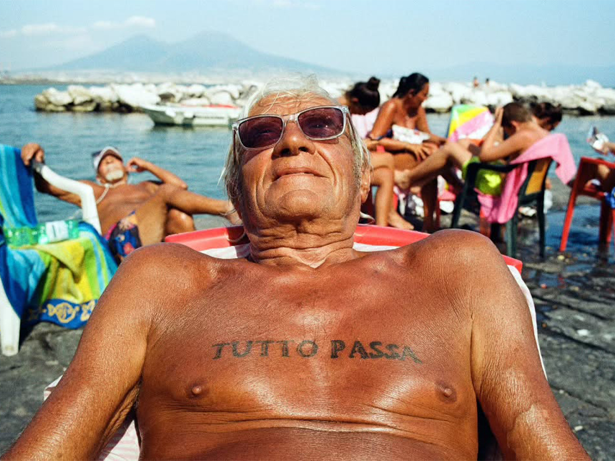 Man reclining on beach in Naples by photographer Robbie McIntosh