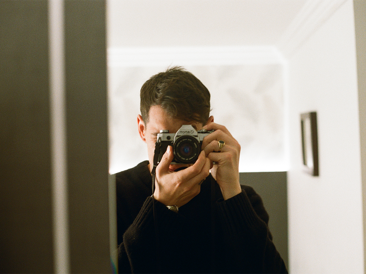 Man taking a photo in the mirror on film camera